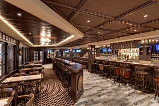A warm and welcoming bar area aboard MSC Grandiosa, featuring rich wood tones and comfortable seating | MSC Cruises