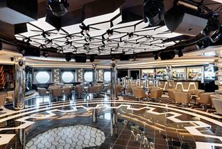 A stylish bar and lounge area on MSC Grandiosa featuring seating, a dance floor, and elegant decor | MSC Cruises