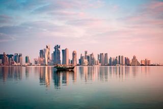 A stunning skyline of Doha reflected in calm waters at dawn, showcasing the beauty of Qatar's architecture | MSC Cruises