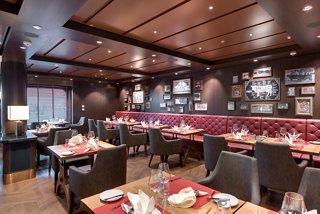 Un elegante comedor con mesas elegantes y cálido decorado de madera, invitando a los huéspedes a disfrutar de una comida memorable | MSC Cruceros