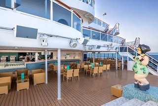Guests enjoy the inviting outdoor bar area aboard MSC Seaview, with tables, chairs, and a vibrant atmosphere | MSC Cruises