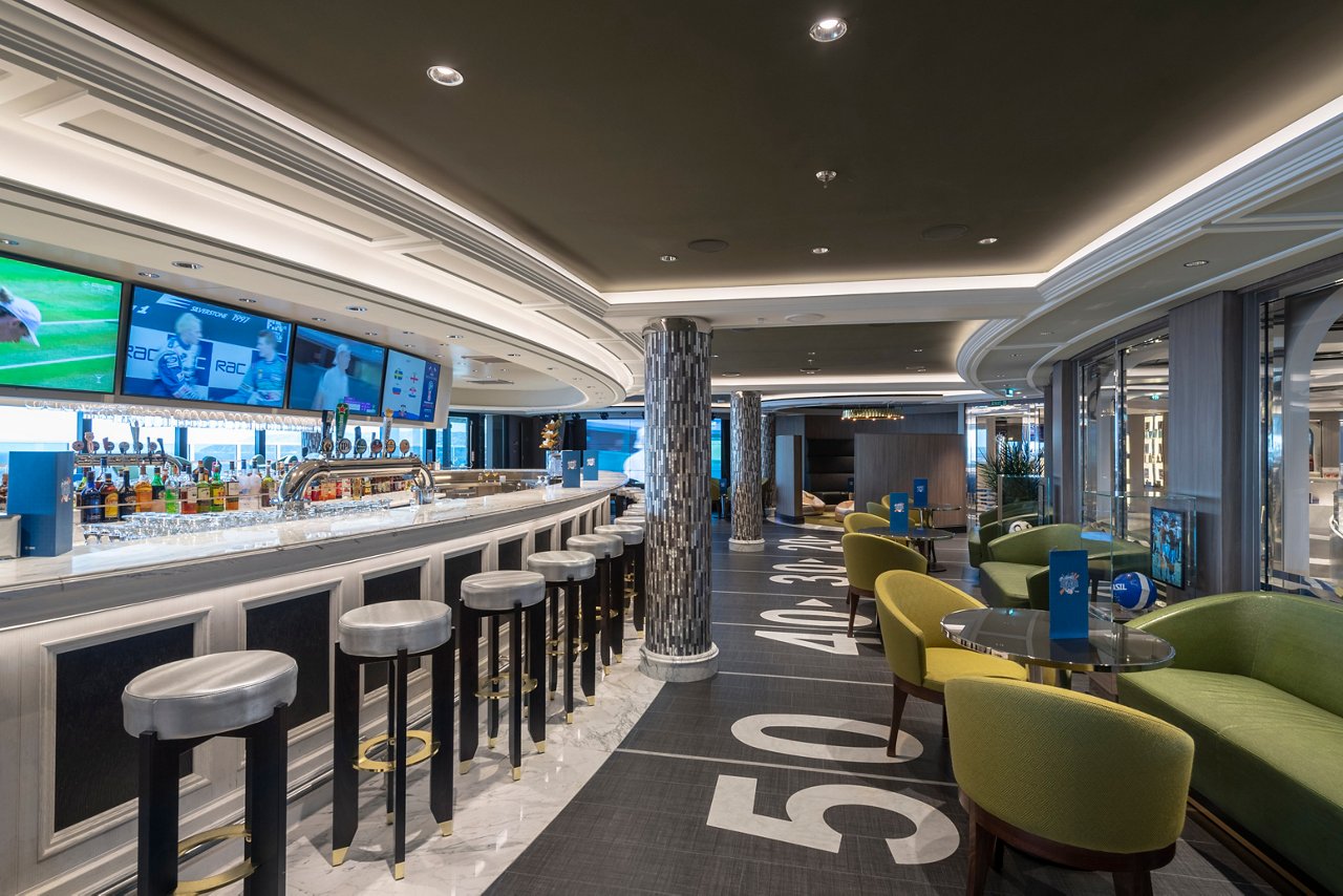 A vibrant sports bar setting with seating, tables, and a bar counter, featuring monitors for entertainment | MSC Cruises