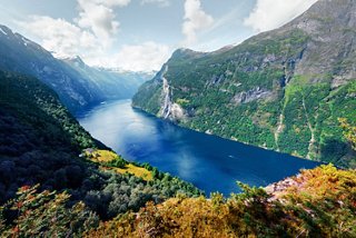 Ein atemberaubender Blick auf den Geirangerfjord, umgeben von üppigen Bergen und ruhigen Gewässern | MSC Cruises