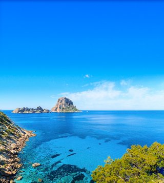 Una vista panoramica mozzafiato di Cala D'Hort a Ibiza, che mostra il tranquillo mare Mediterraneo e il cielo sereno | MSC Crociere