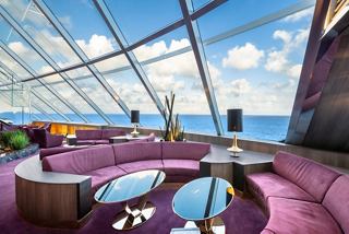 A luxurious sitting area in the Top Sail Lounge, featuring panoramic windows with stunning sea views | MSC Cruises
