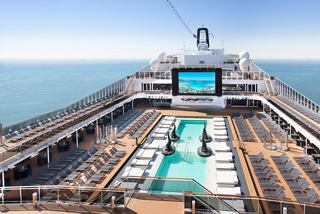 A panoramic view of the MSC Bellissima's pool deck with an inviting swimming pool and a large LED screen | MSC Cruises
