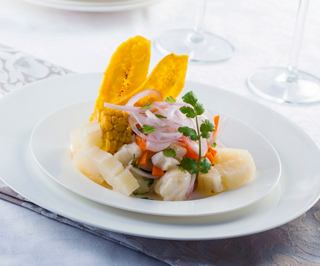 A vibrant plate of Belizean ceviche garnished with fresh herbs and fruit, showcasing the culinary delights of the region | MSC Cruises