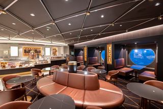 A stylish lounge area with comfortable seating and a warm atmosphere invites relaxation and conversation | MSC Cruises