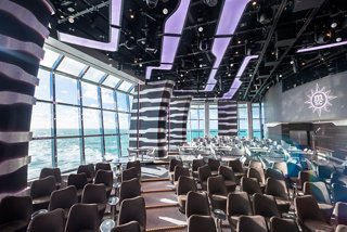 A beautifully designed lounge with large windows, offering stunning views and comfortable seating for guests | MSC Cruises