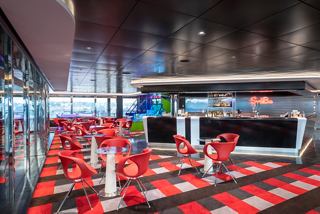 A vibrant sports bar featuring tables and a bar counter, inviting guests to relax and enjoy the atmosphere | MSC Cruises