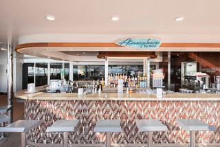 A vibrant bar area on MSC Grandiosa, showcasing the inviting Atmosphere Bar North with seating and a welcoming ambiance | MSC Cruises