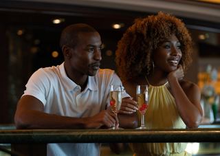 Ein Paar genießt zusammen Getränke an der Bar an Bord der MSC Orchestra und teilt einen Moment der Verbundenheit und Freude | MSC Cruises