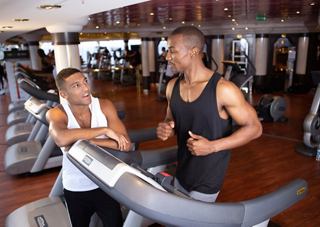 Two friends enjoy a workout at the gym on MSC Orchestra | MSC Cruises