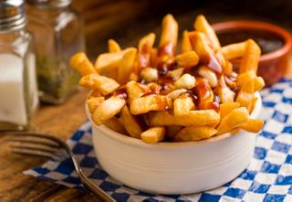 A bowl of golden fries topped with sauce, served as a delicious snack option | MSC Cruises