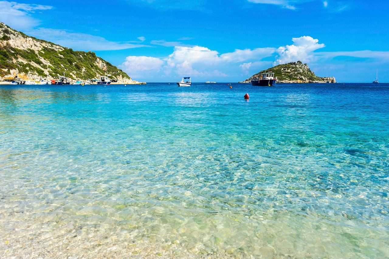 A serene beach with clear turquoise waters and gentle waves, inviting relaxation and exploration in Zakynthos | MSC Cruises