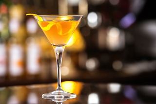 A vibrant premium cocktail served in a martini glass on a bar counter | MSC Cruises