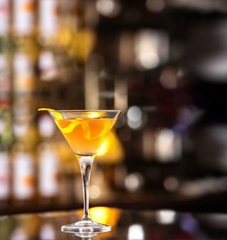 A vibrant orange cocktail served in a martini glass on a bar counter | MSC Cruises