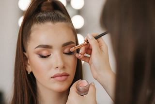 A beauty expert applying eye shadow to enhance a woman's look during an express makeup session | MSC Cruises