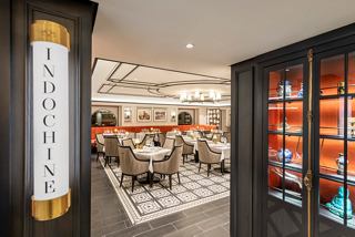Una vista cálida y acogedora de la entrada del restaurante Indochine en MSC Virtuosa, que muestra su elegante diseño interior | MSC Cruceros