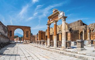 Ancient ruins of Pompeii with impressive columns under a bright blue sky, inviting exploration and discovery | MSC Cruises