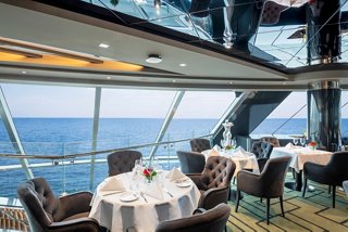 A beautifully arranged dining table in the MSC Yacht Club Restaurant, with sea views and elegant decor | MSC Cruises