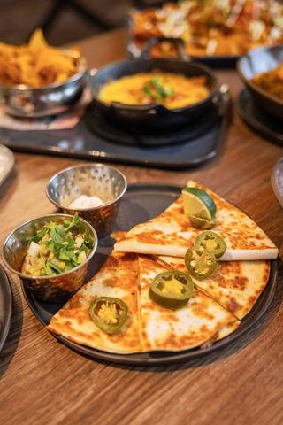A vibrant spread of delicious dishes featuring tacos and sides on a wooden table | MSC Cruises