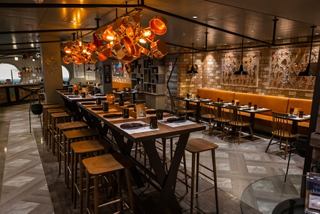 A welcoming dining area with warm lighting and a long wooden table set for an enjoyable meal | MSC Cruises