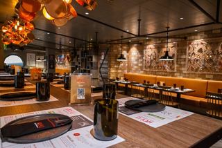 A warm and inviting dining area featuring wooden tables and vibrant decor at Hola! Tacos & Cantina | MSC Cruises