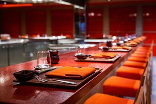 A vibrant dining area featuring orange seating and a welcoming atmosphere for enjoying Japanese cuisine | MSC Cruises