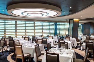Elegant dining area with tables and chairs, featuring large windows and natural light | MSC Cruises