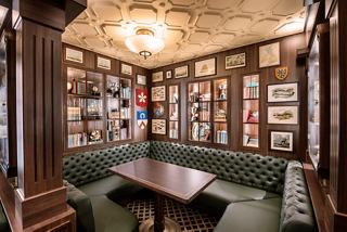 A cosy sitting area featuring a table and sofas, surrounded by shelves filled with books | MSC Cruises