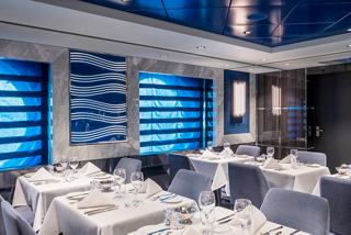 An elegant restaurant on the MSC Virtuosa featuring light blue decor and neatly arranged tables for a delightful dining experience | MSC Cruises