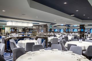 A spacious dining area with elegantly set tables and chairs, creating an inviting atmosphere for guests | MSC Cruises