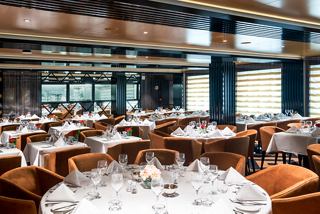 Elegant dining setup in the Il Campo Restaurant, featuring neatly arranged tables and a warm atmosphere | MSC Cruises