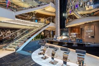 The vibrant atrium of MSC Seashore features a stylish bar area with seating and modern decor | MSC Cruises
