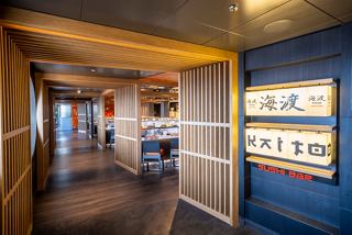 A corridor leading to the Kaito Sushi Bar, featuring signage and warm lighting in an inviting atmosphere | MSC Cruises