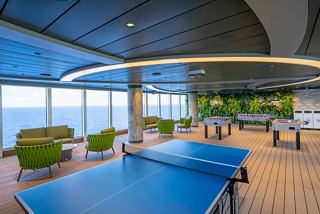 A vibrant Jungle Pool Lounge featuring ping pong tables and comfortable seating with panoramic ocean views | MSC Cruises