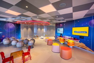 Una vibrante zona Mini Club en MSC Seashore, diseñada para niños con juegos, juguetes y asientos coloridos | MSC Cruceros