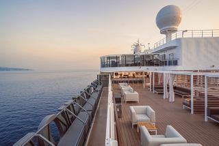 A serene view of the sun deck bar on MSC Seashore, overlooking calm waters and a beautiful sky | MSC Cruises