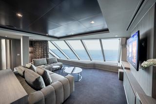 Sitzbereich in der MSC Yacht Club Owners Suite mit Panoramafenstern und gemütlichem Sofa | MSC Cruises