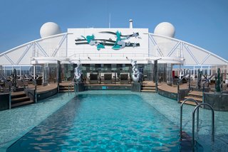El área One Pool del MSC Yacht Club cuenta con una piscina vibrante rodeada de tumbonas y esculturas | MSC Cruceros