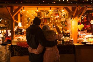Una pareja se abraza en un puesto festivo lleno de decoraciones navideñas y souvenirs | MSC Cruceros