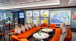 A vibrant lounge area with orange seating and colourful artwork, designed for relaxation and socialising | MSC Cruises