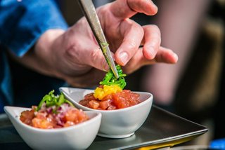 Una mano coloca delicadamente verduras frescas en tazones, mostrando opciones vegetarianas vibrantes | MSC Cruceros