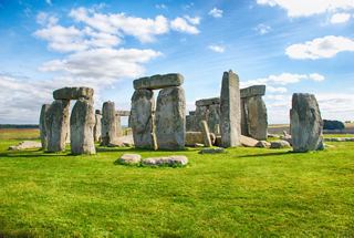 The ancient Stonehenge stone circle stands majestically on green grass under a bright sky | MSC Cruises