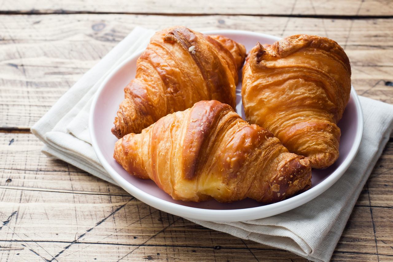 A freshly baked croissant resting on a plate, perfect for breakfast or room service | MSC Cruises