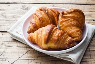 Un croissant recién horneado reposando en un plato, perfecto para el desayuno o el servicio a la habitación | MSC Cruceros