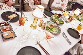 Una mesa de comedor elegantemente dispuesta con una variedad de platos, invitando a los invitados a disfrutar de una deliciosa comida juntos | MSC Cruceros