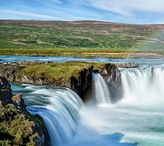Una vista mozzafiato di una cascata circondata da verde lussureggiante e un fiume sereno | MSC Crociere