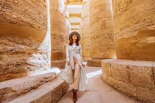 A woman explores the ancient ruins of the Temple of Karnak in Luxor, surrounded by impressive columns | MSC Cruises